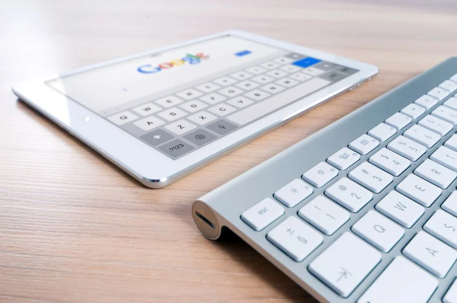 Une tablette moderne et un smartphone affichant du contenu web sur une surface réfléchissante, mettant en avant la technologie et la connectivité.